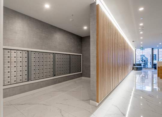 A long hallway with a marble floor and a wooden wall on the right side.