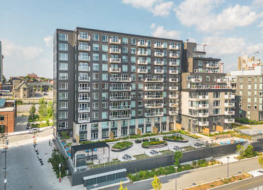 A large, modern apartment building with a courtyard in the front.