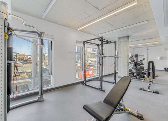 A gym with a view of the city outside the window.