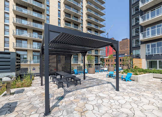 A patio with a table and chairs under a black awning.