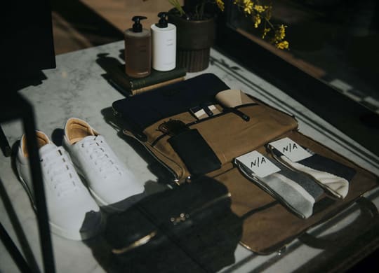 a table with a pair of white shoes and a bag