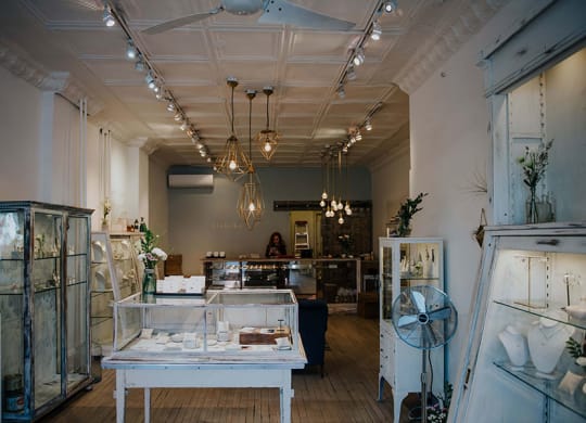 a store with glass cases and lights on the ceiling