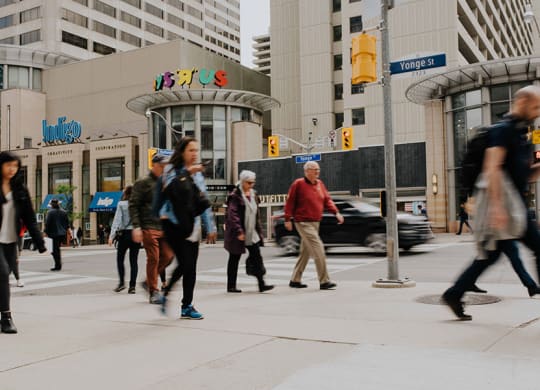 a group of people crossing a busy city street