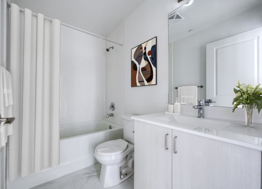 a white bathroom with a toilet and a tub and a sink
