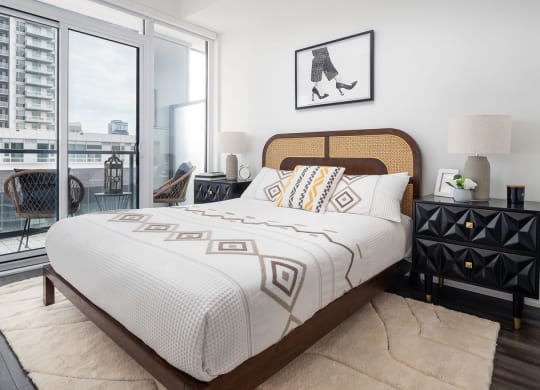 bed with balcony on the left side and views of downtown toronto