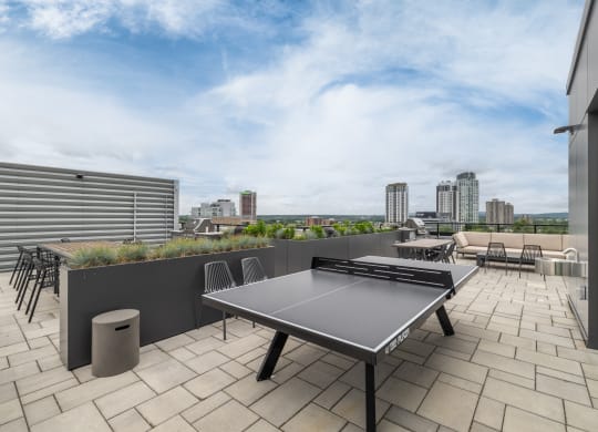 a terrace with a ping pong table and a view of the city