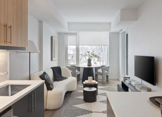 a living room with a couch and a table in front of a window