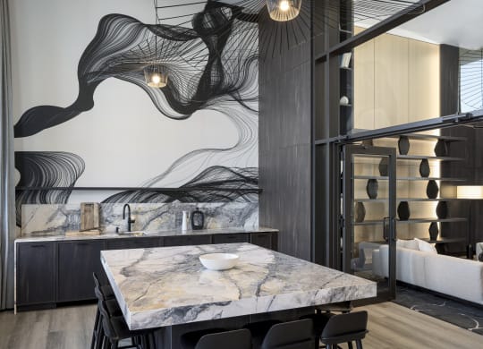 a kitchen with marble countertops and a table with black chairs