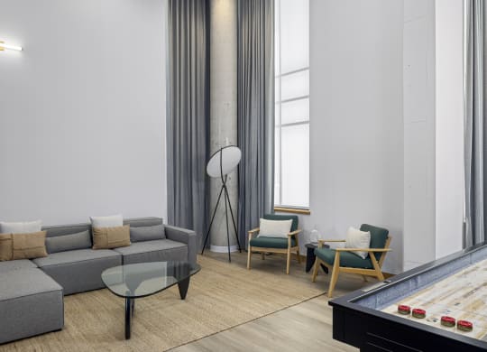 a living room with couches and chairs and a pool table