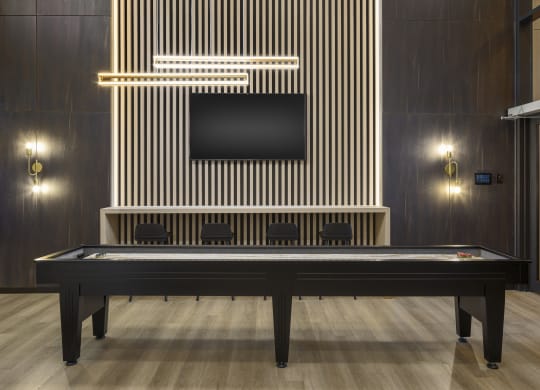 a billiards table in a room with a tv on the wall
