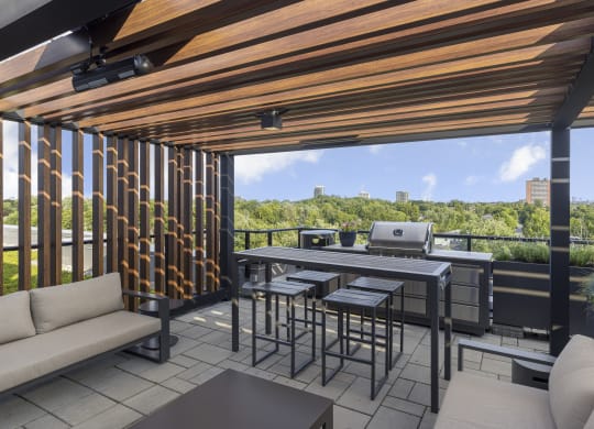 a patio with a grill and a table with chairs