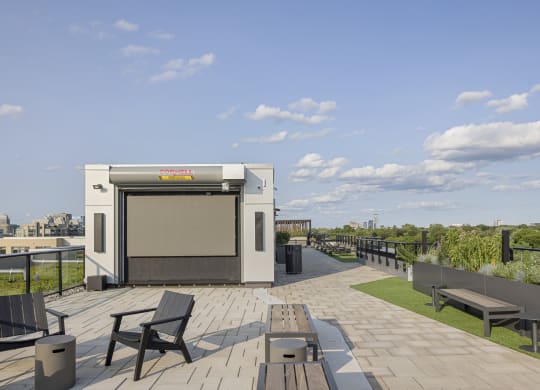 a cube on the roof of a building with benches and tables