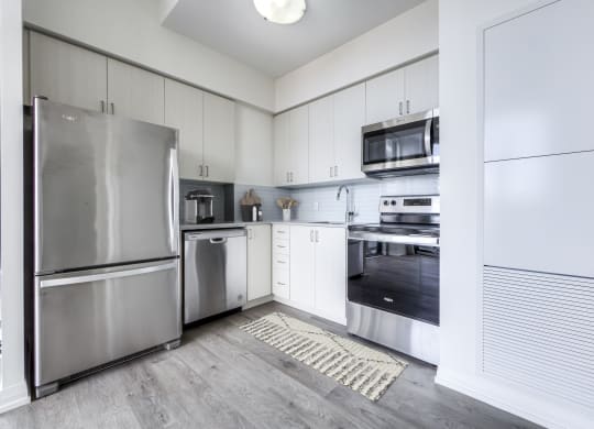 a kitchen with stainless steel appliances and white cabinets