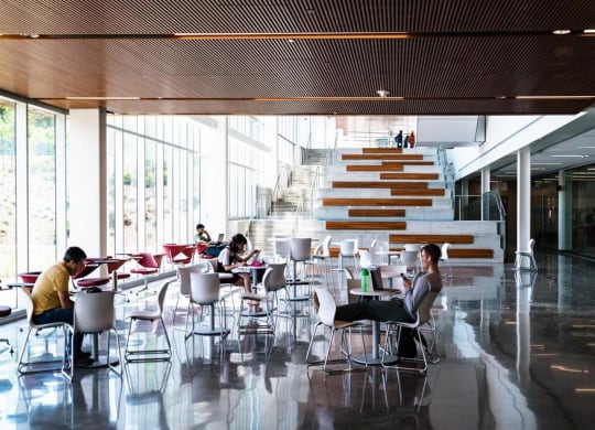 people sitting at tables in a lobby of a building
