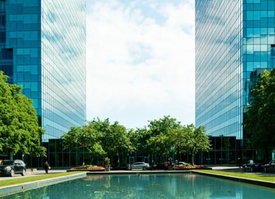 two tall buildings next to a large pool of water