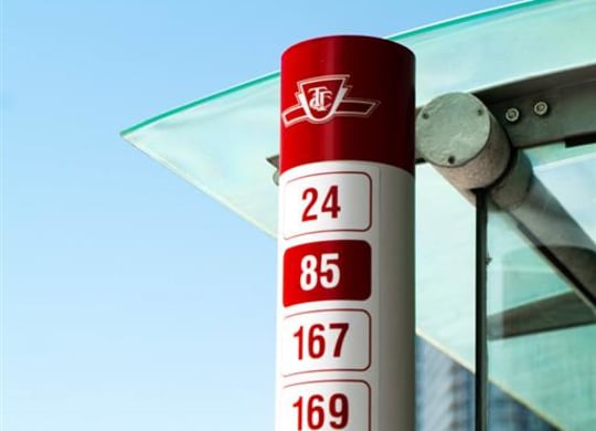 a gas price sign in front of a bus stop