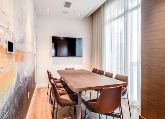 a conference room with a table and chairs and a television