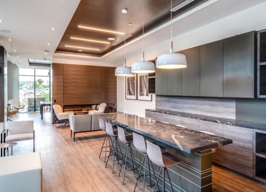 a large kitchen with a long counter and chairs