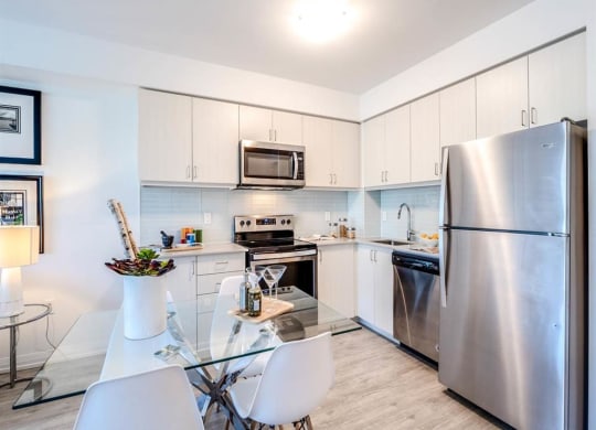 a kitchen with stainless steel appliances and a glass table