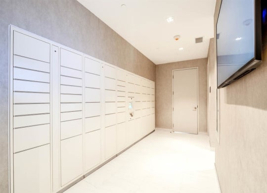 a long hallway with white cabinets and a door