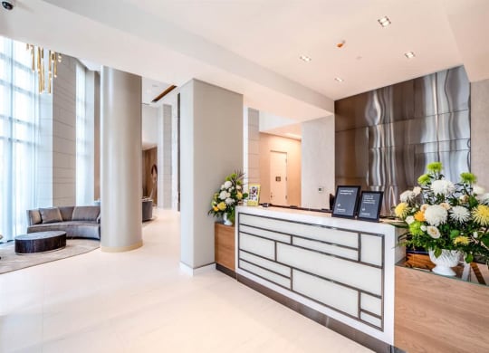 the lobby of a hotel with a reception desk and flowers