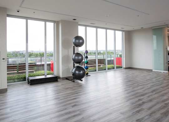 a large room with floor to ceiling windows and a yoga room with spheres in it