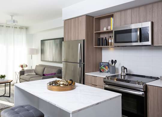 A modern kitchen with a refrigerator, oven, and sink.
