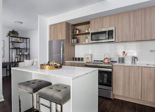 A modern kitchen with a white countertop and wooden cabinets.