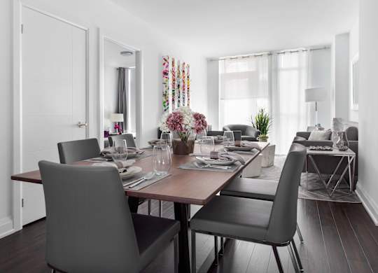 A dining room with a table set for a meal.