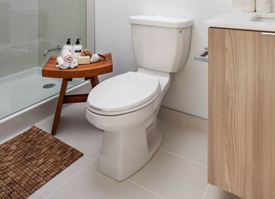 A white toilet sits next to a sink in a modern bathroom.