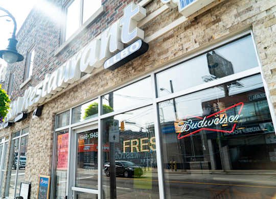 the front of a building with a bud light sign in the window