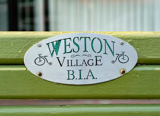 a sign on a green bench that reads bla