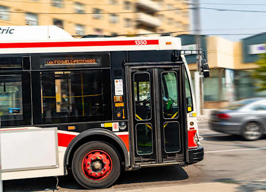 A city bus with the number 1350 on the front is in motion.