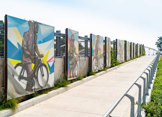 A long row of artistic murals depicting people and bicycles.