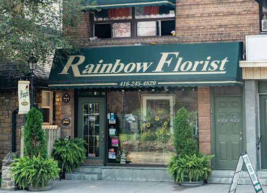 A flower shop named Rainbow Florist is located on a street corner.