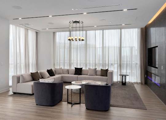 A modern living room with a white sofa set and a grey coffee table.