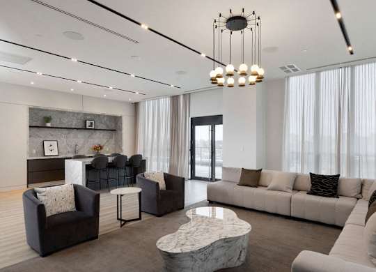 A modern living room with a marble coffee table and a chandelier.