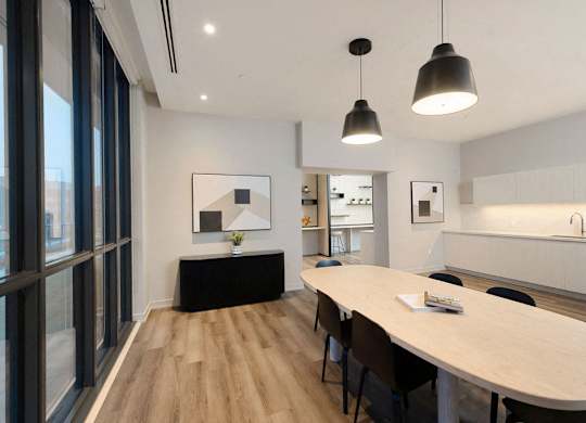 A modern dining room with a long table and chairs.
