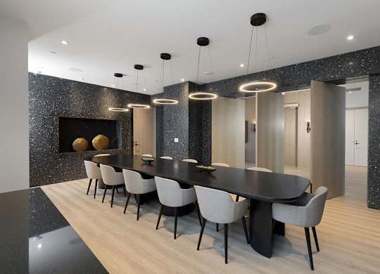 A modern dining room with a black table and chairs.