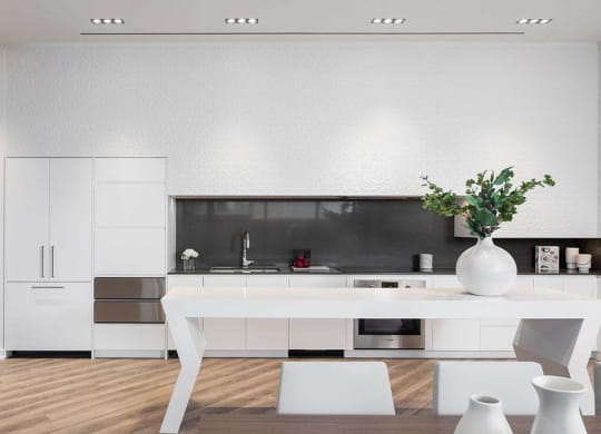 a white kitchen with a white table and white chairs