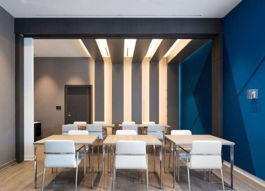 a conference room with tables and chairs and a blue wall