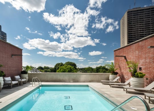 a swimming pool on the rooftop of a building with a blue sky