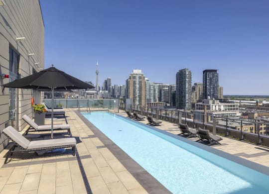 the pool on the rooftop of a building with a view of the city