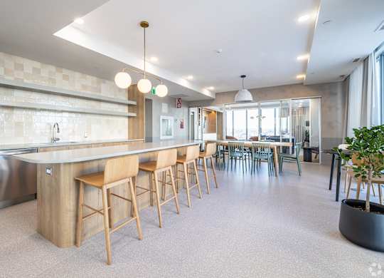 A modern kitchen with a long island and bar stools.