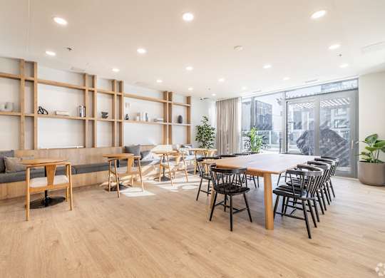 A modern living room with a long wooden table and chairs.