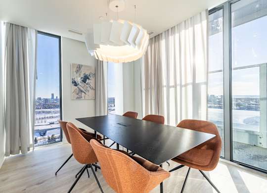 A modern dining room with a large table and chairs.