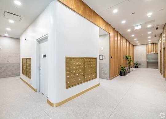 A white hallway with a wooden wall and a white door.