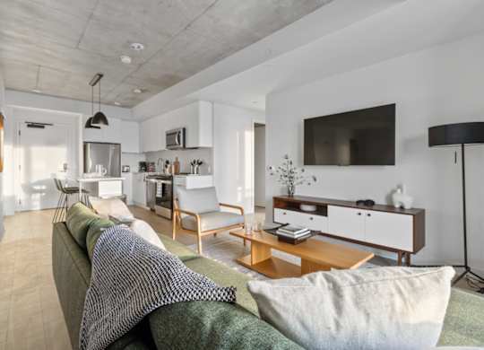 A modern living room with a grey couch and a wooden coffee table.