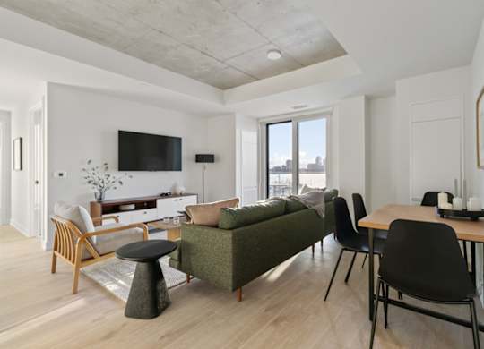 A living room with a green couch and a wooden table.