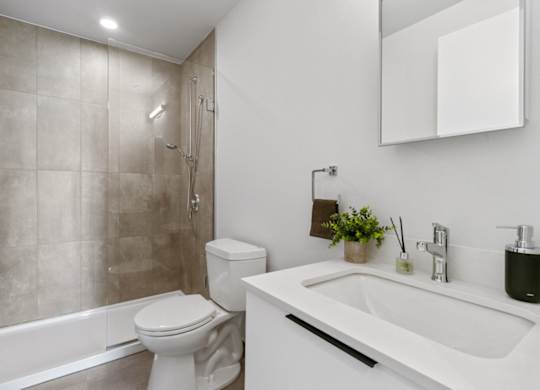 A white toilet sits next to a white sink in a bathroom.